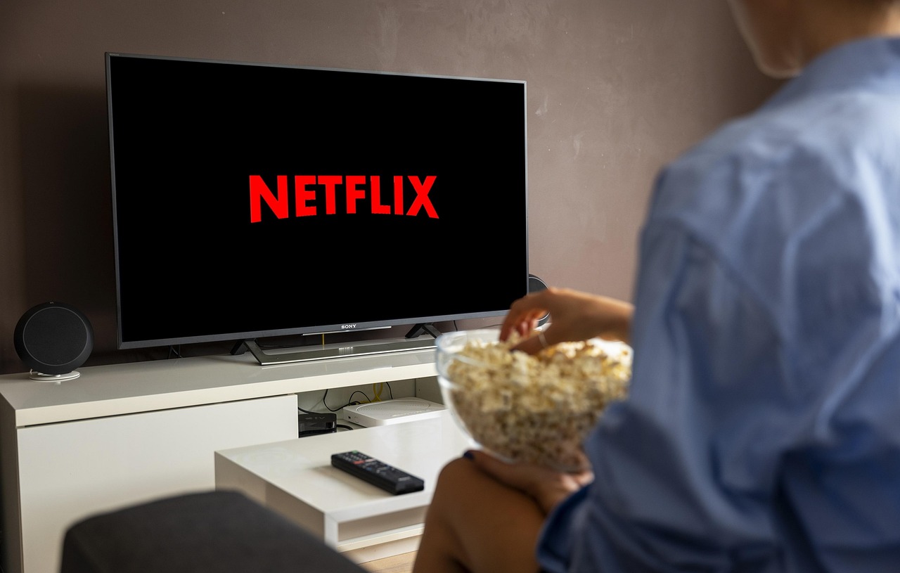 テレビでNetflixを見ながらポップコーンを食べる人